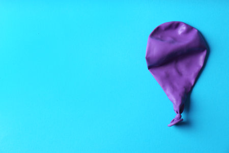 Purple deflated balloon on color background, top view with space for textの写真素材