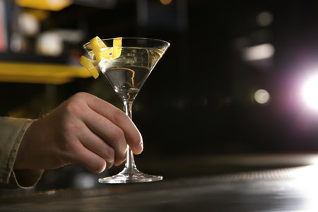 Barman with glass of lemon drop martini cocktail in pub, closeup. Space for textの写真素材