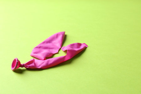 Popped balloon on color background, space for textの写真素材