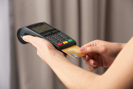 Woman using modern payment terminal indoors, closeup