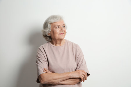 Portrait of elderly woman on light background