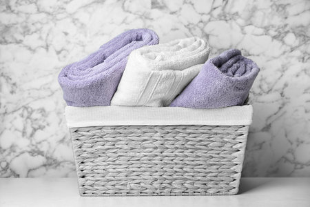Basket with soft bath towels on tableの写真素材