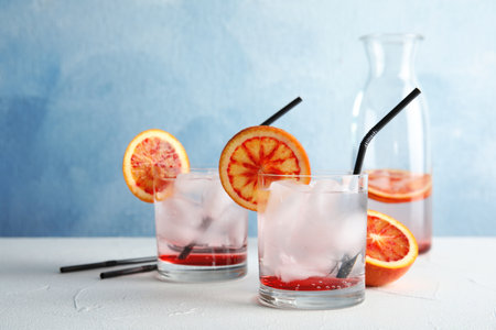Composition with orange drink and ice cubes in glasses on table. Space for textの写真素材