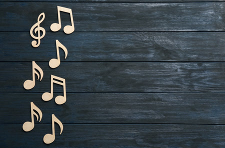 Music notes and treble clef on wooden background, top view. Space for textの写真素材