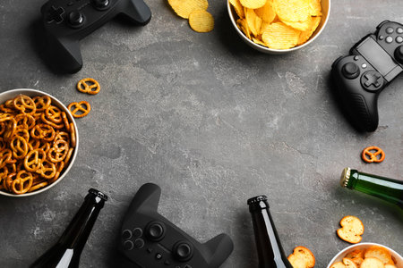 Flat lay composition with video game controllers, snacks and space for text on gray backgroundの写真素材