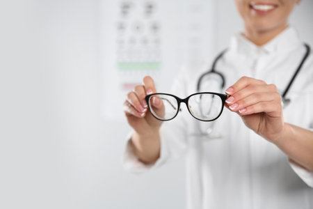Female ophthalmologist with eyeglasses in clinic, closeup. Space for textの写真素材