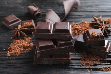 Pieces of black chocolate on wooden tableの写真素材