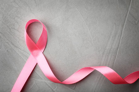 Pink ribbon on gray background, top view with space for text. breast cancer awareness conceptの写真素材