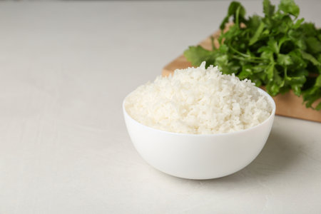 Bowl of boiled rice on light table. Space for textの写真素材