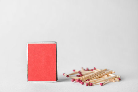 Cardboard box and matches on light background. space for designの写真素材