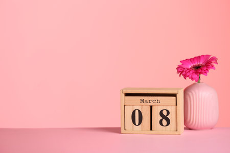 Calendar and vase with flower on table against color background, space for text. International Women's Dayの写真素材