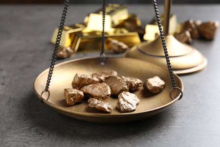 Scale pan with gold lumps on gray table, closeupの写真素材