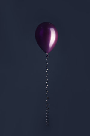Color balloon with ribbon on dark backgroundの写真素材