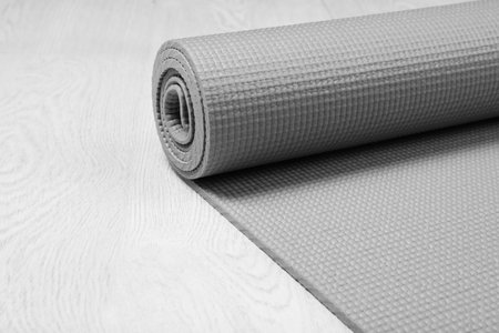 Rolled sports mat on wooden background. Space for textの写真素材