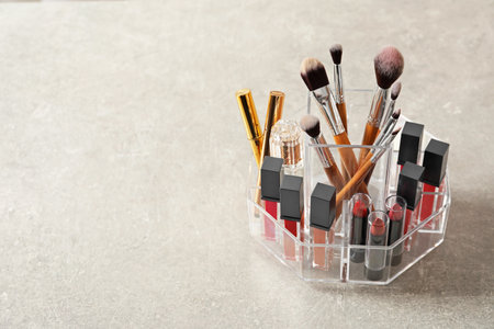 Lipstick holder with different makeup products on gray background. Space for textの写真素材