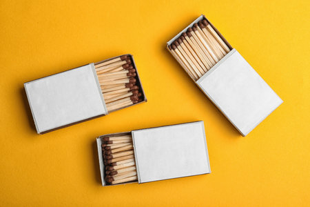 Cardboard boxes with matches on color background, flat lay. space for designの写真素材