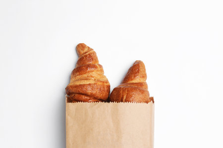 Paper bag with croissants on white background, top view. space for designの写真素材