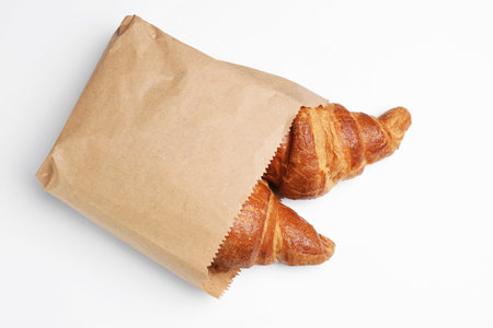 Paper bag with croissants on white background, top view. space for designの写真素材