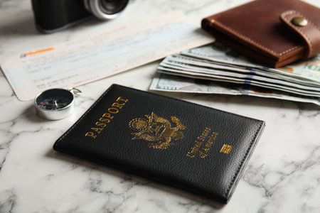 Composition with passport, compass and money on marble table. travel agency