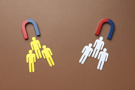 Magnets attracting paper people on color background, flat lay. marketing conceptの写真素材