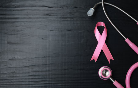 Pink ribbon and stethoscope on wooden background, top view with space for text. breast cancer conceptの写真素材