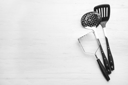 Different kitchen utensils on wooden background, top view with space for textの写真素材