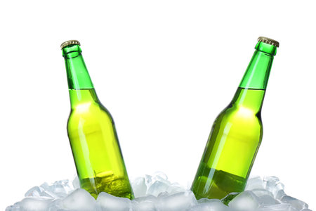 Bottles of beer on ice cubes against white backgroundの写真素材