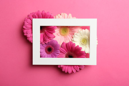 Flat lay composition with beautiful flowers and frame on color backgroundの写真素材