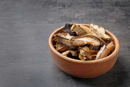 Bowl of dried mushrooms on color background. Space for textの写真素材