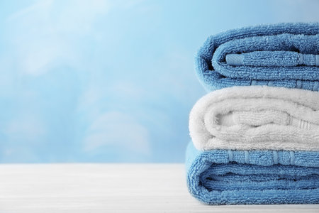 Stack of soft bath towels on table. Space for textの写真素材
