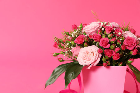 Beautiful bouquet of flowers in paper gift box on color background. Space for textの写真素材