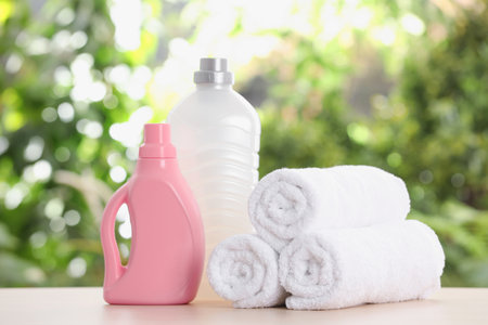 Soft bath towels and laundry detergents on table against blurred backgroundの写真素材