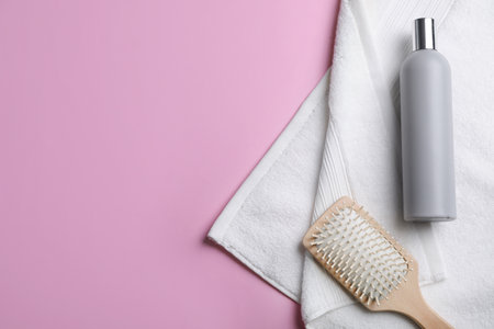 Bottle of shampoo, towel and brush on color background, top view with space for textの写真素材