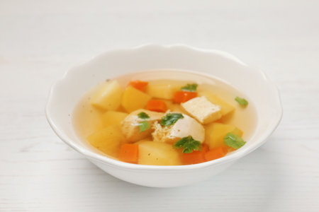 Dish with fresh homemade chicken soup on wooden tableの写真素材