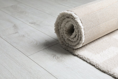 Rolled fuzzy carpet on wooden background. Space for textの写真素材