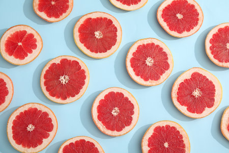 Fresh sliced ripe grapefruit on color background, flat layの写真素材