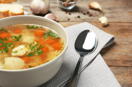 Bowl with fresh homemade chicken soup on wooden table, space for textの写真素材