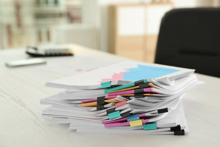 Stack of documents with paper clips on office tableの写真素材