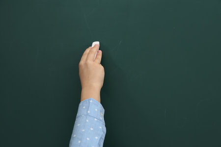 Little child writing on chalkboard, closeup. Space for textの写真素材
