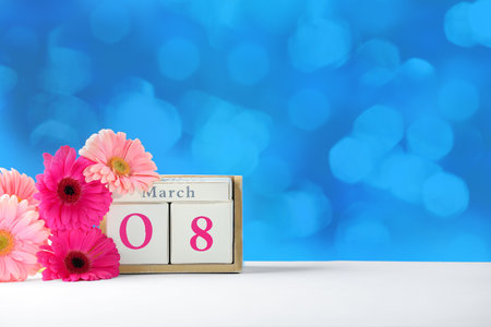 Calendar and flowers on table against color background, space for text. International Women's Dayの写真素材