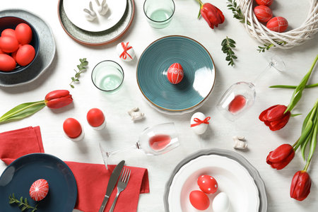 Festive Easter table setting with painted eggs on wooden background, flat layの写真素材