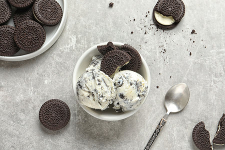 Flat lay composition with bowl of chocolate cookies ice cream on gray backgroundの写真素材
