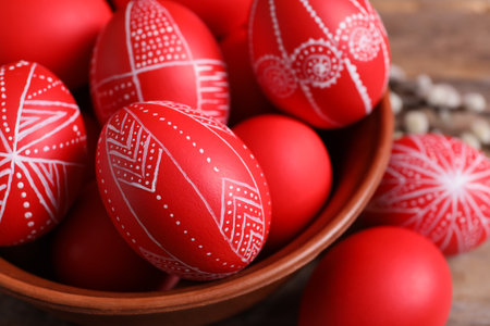 Wooden bowl with red painted Easter eggs on table, closeupの写真素材