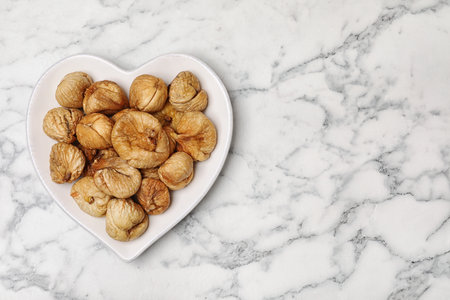 Plate of figs on marble background, top view with space for text. Dried fruit as healthy foodの写真素材