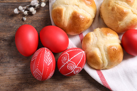 Red painted Easter eggs and buns on wooden table, top viewの写真素材