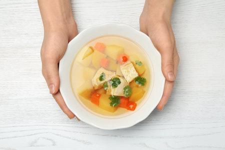 Woman eating fresh homemade chicken soup at table, top viewの写真素材