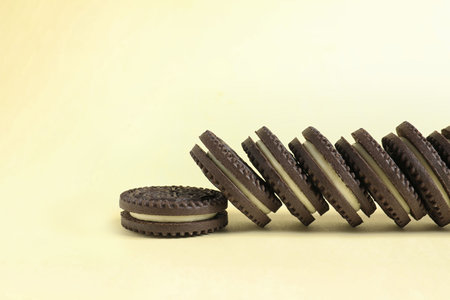 Tasty chocolate cookies with cream on color background. Space for text
