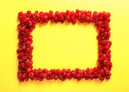 Frame made of cherries on color background, top view with space for text. Dried fruits as healthy foodの写真素材