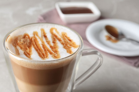 Glass with caramel macchiato on table, closeupの写真素材