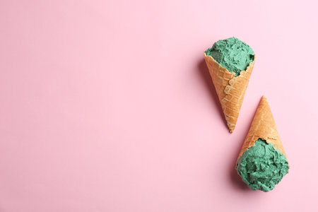 Delicious spirulina ice cream cones on color background, top view. Space for textの写真素材